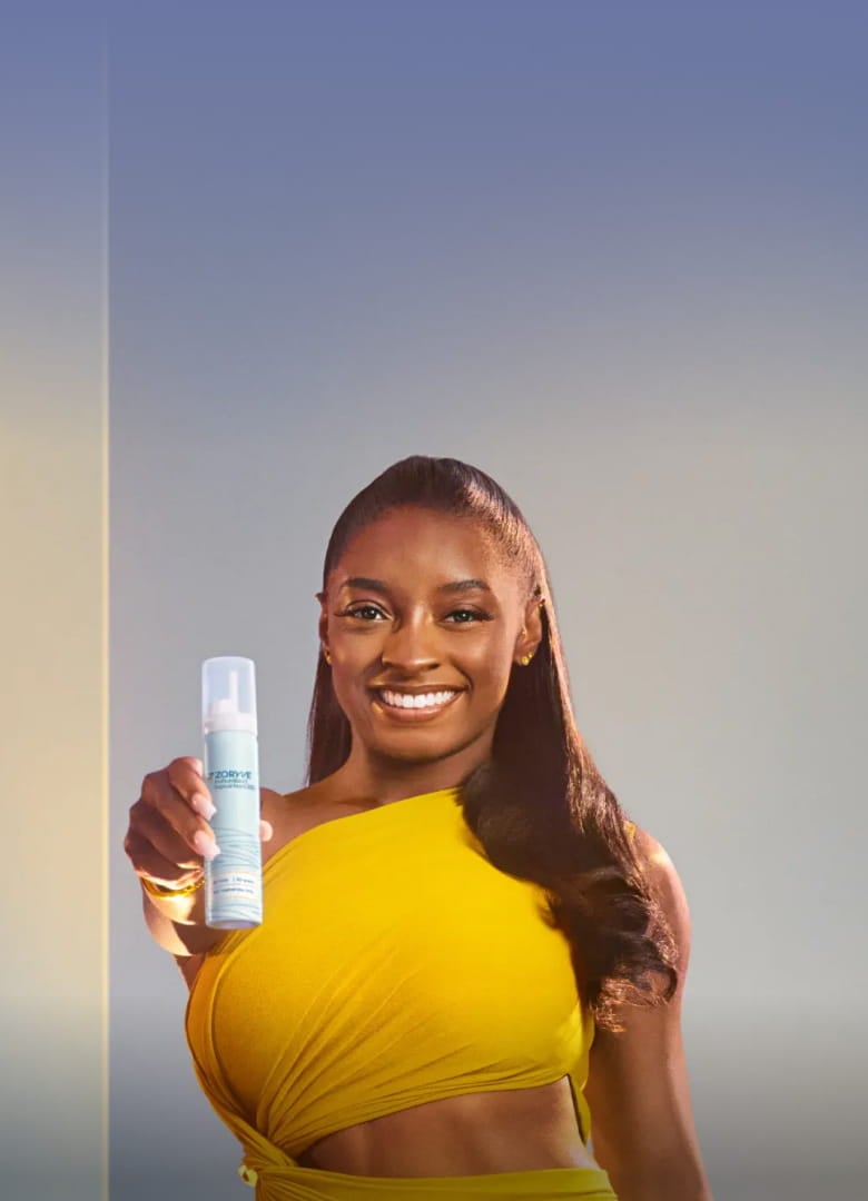 World Champion Gymnast & ZORYVE® (roflumilast) topical foam, 0.3% Patient, Simone Biles, Holding ZORYVE Foam